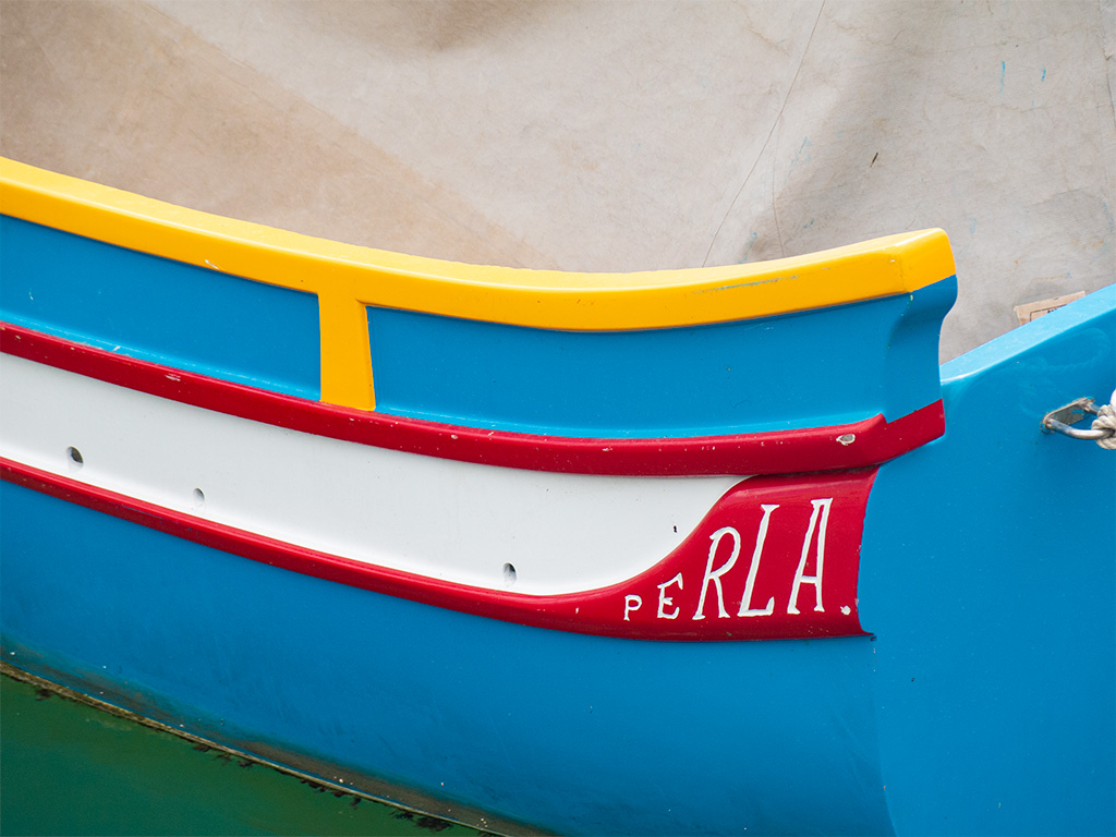 Burta tradycyjnej maltańskiej łodzi: niebieski, żółty, biały czerwony. Nazwa: PERLA